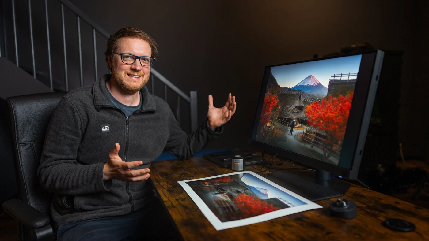 Albert Dros bespreekt een foto achter zijn monitor